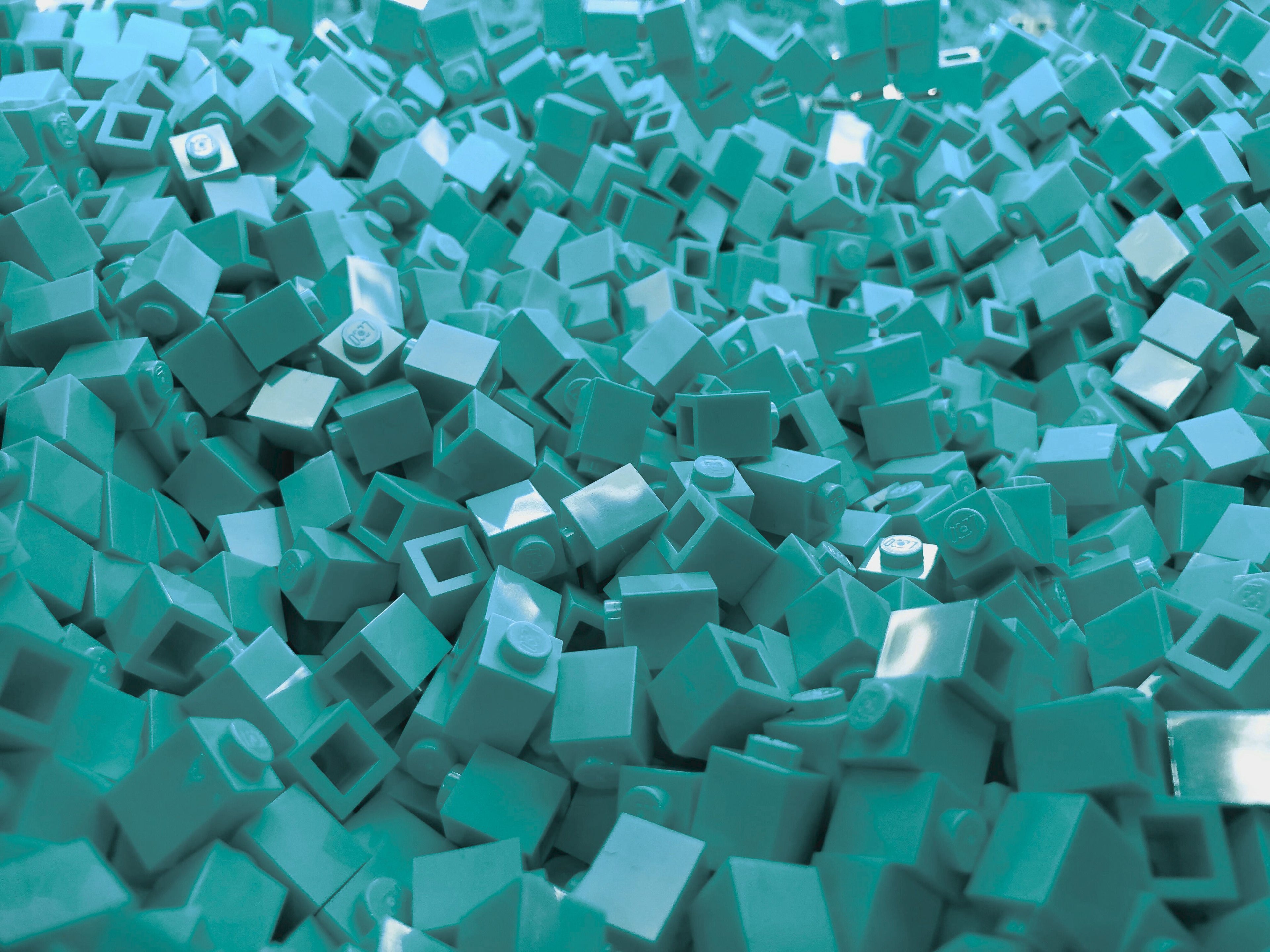 Pile of teal mini building blocks – creative Beyond Bricks toy background.