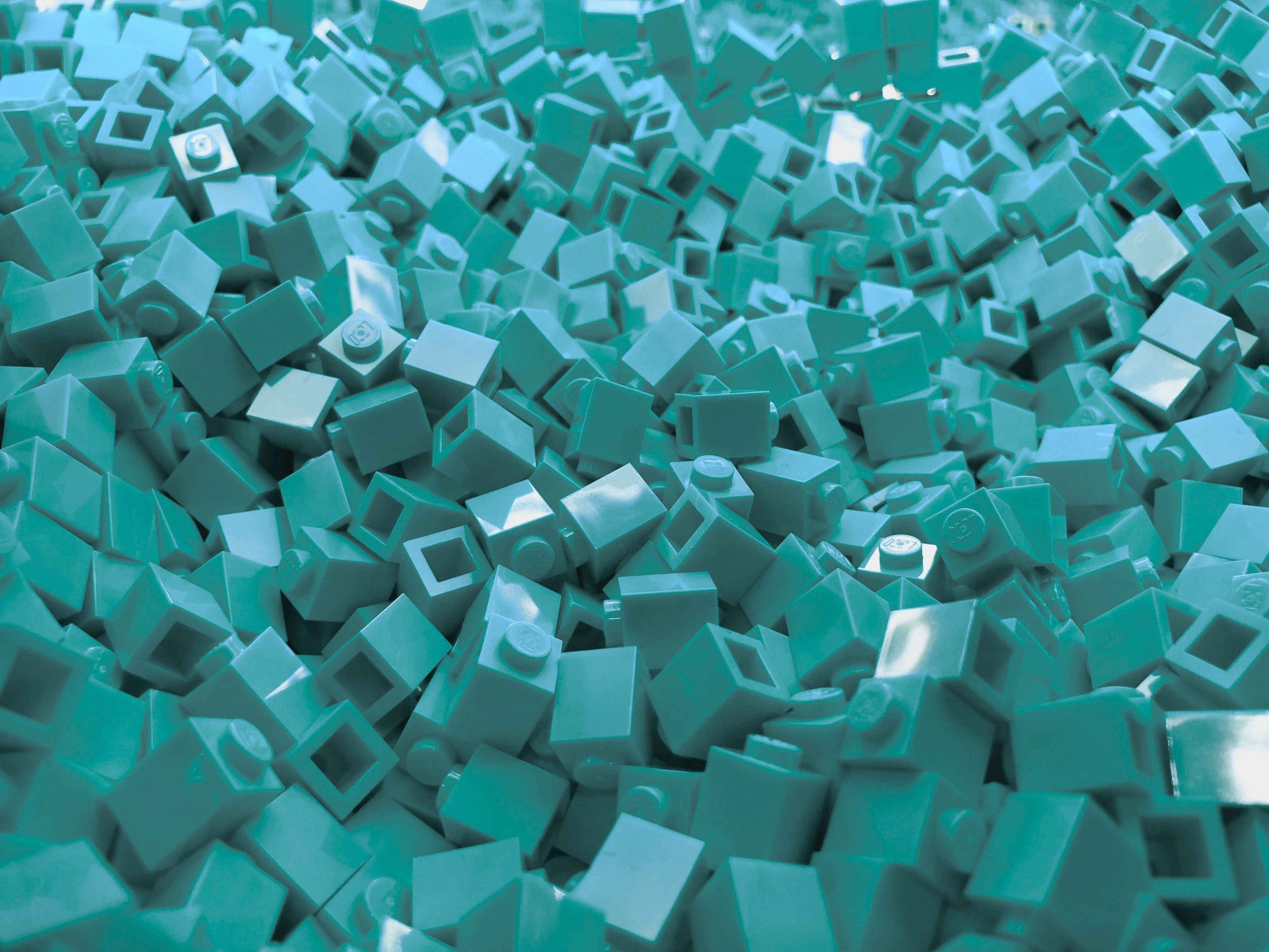Pile of teal mini building blocks – creative Beyond Bricks toy background.